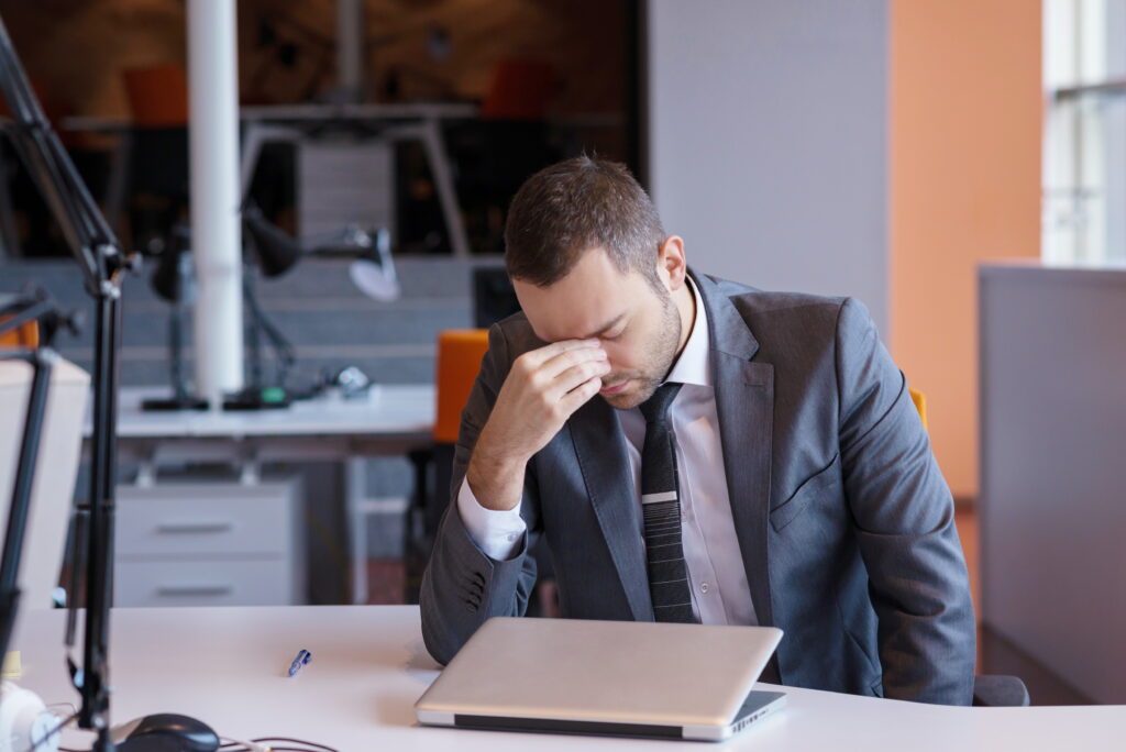 frustrated young business man working on laptop computer at office